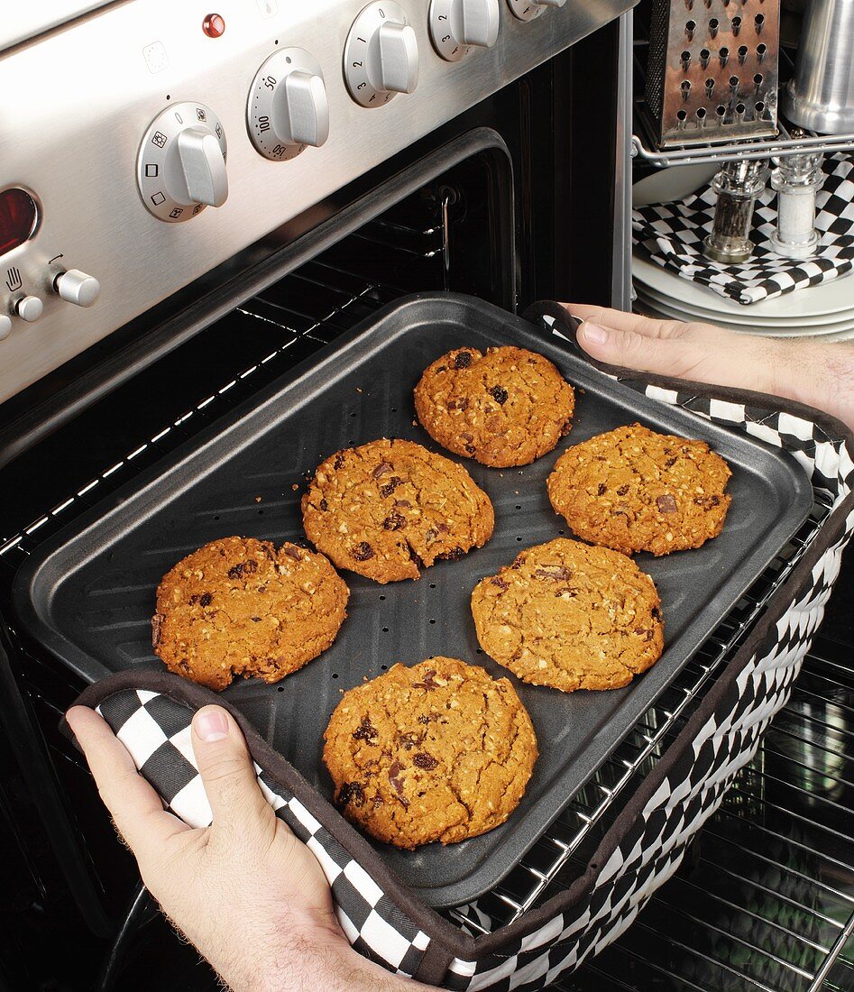Man taking cookies out of the oven