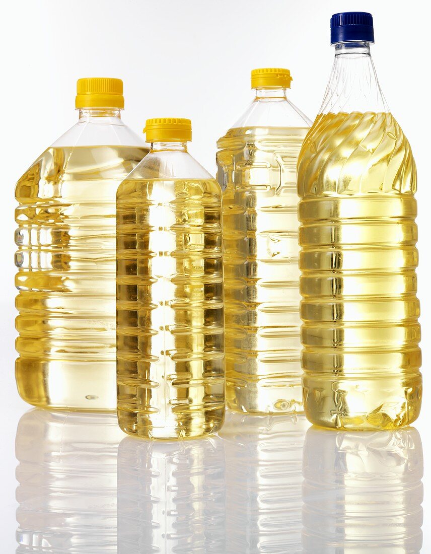 Corn oil in four plastic bottles