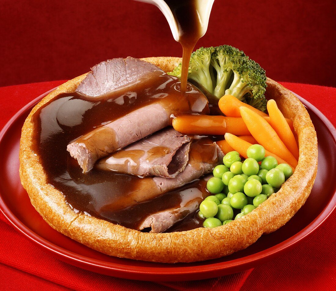 Roast beef with gravy and vegetables in Yorkshire pudding