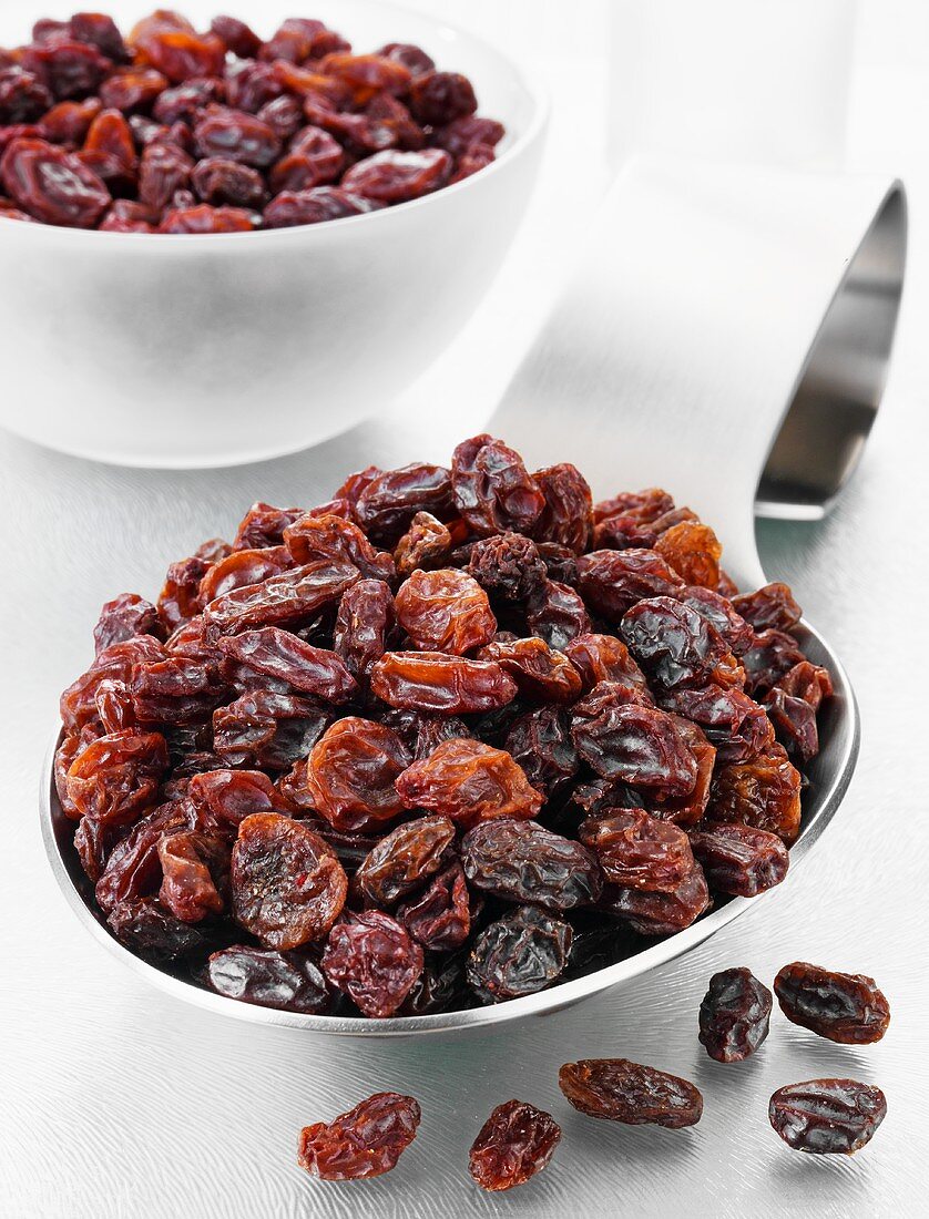 Raisins on a spoon and in a glass bowl