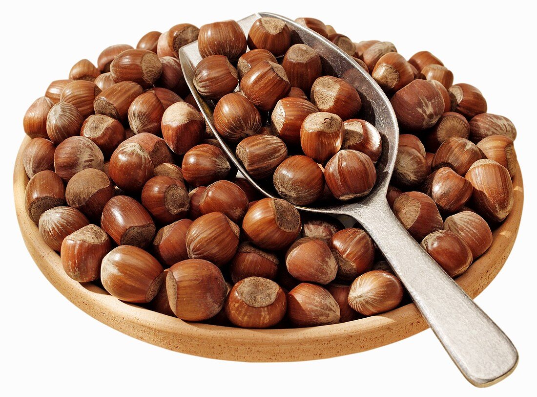 Hazelnuts in a terracotta dish with scoop