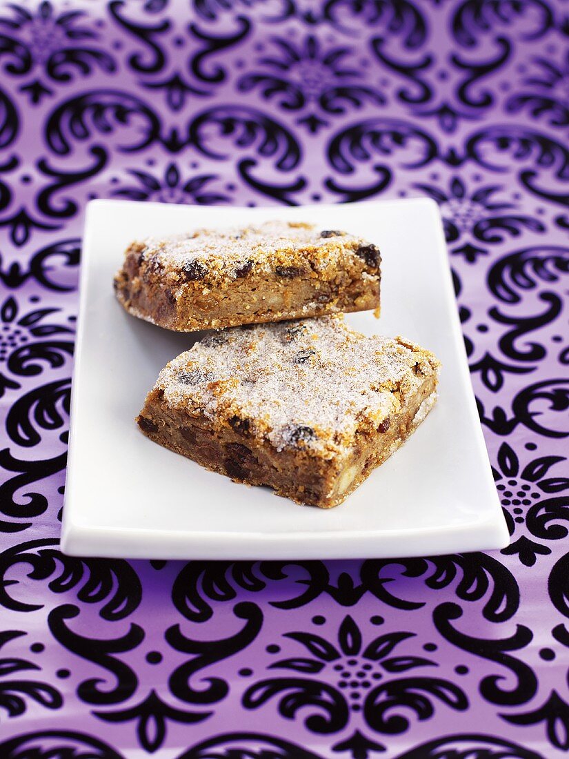 Bread pudding slices with raisins and nuts on a plate