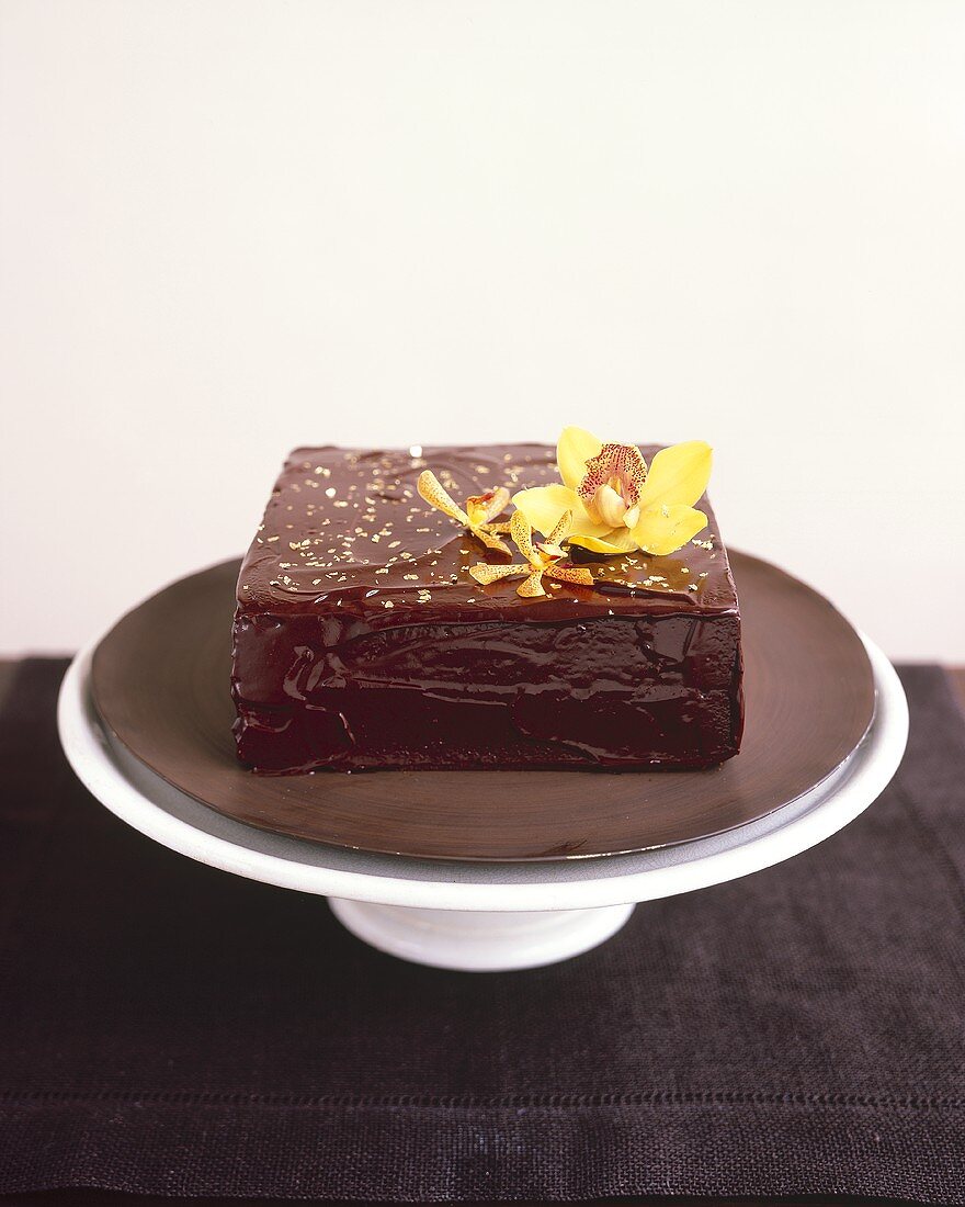 A square chocolate cake with gold