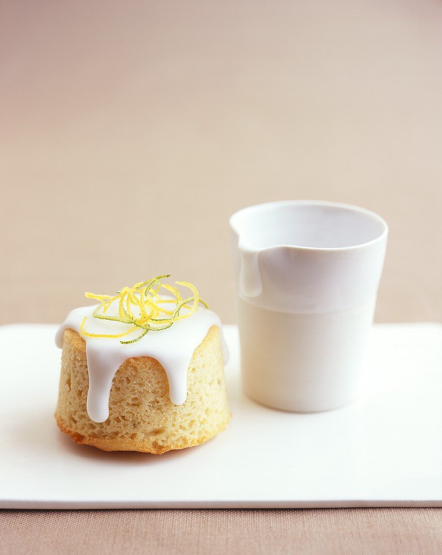 Small iced lemon cake with a small jug