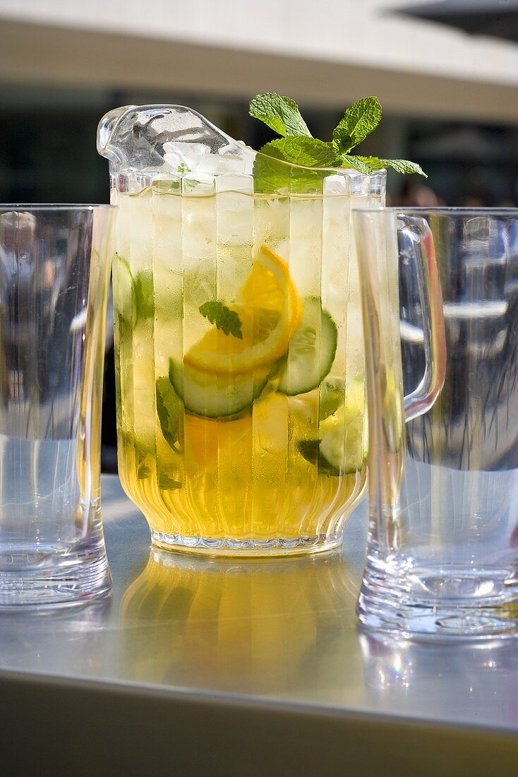 Orange and mint punch in a jug with glasses
