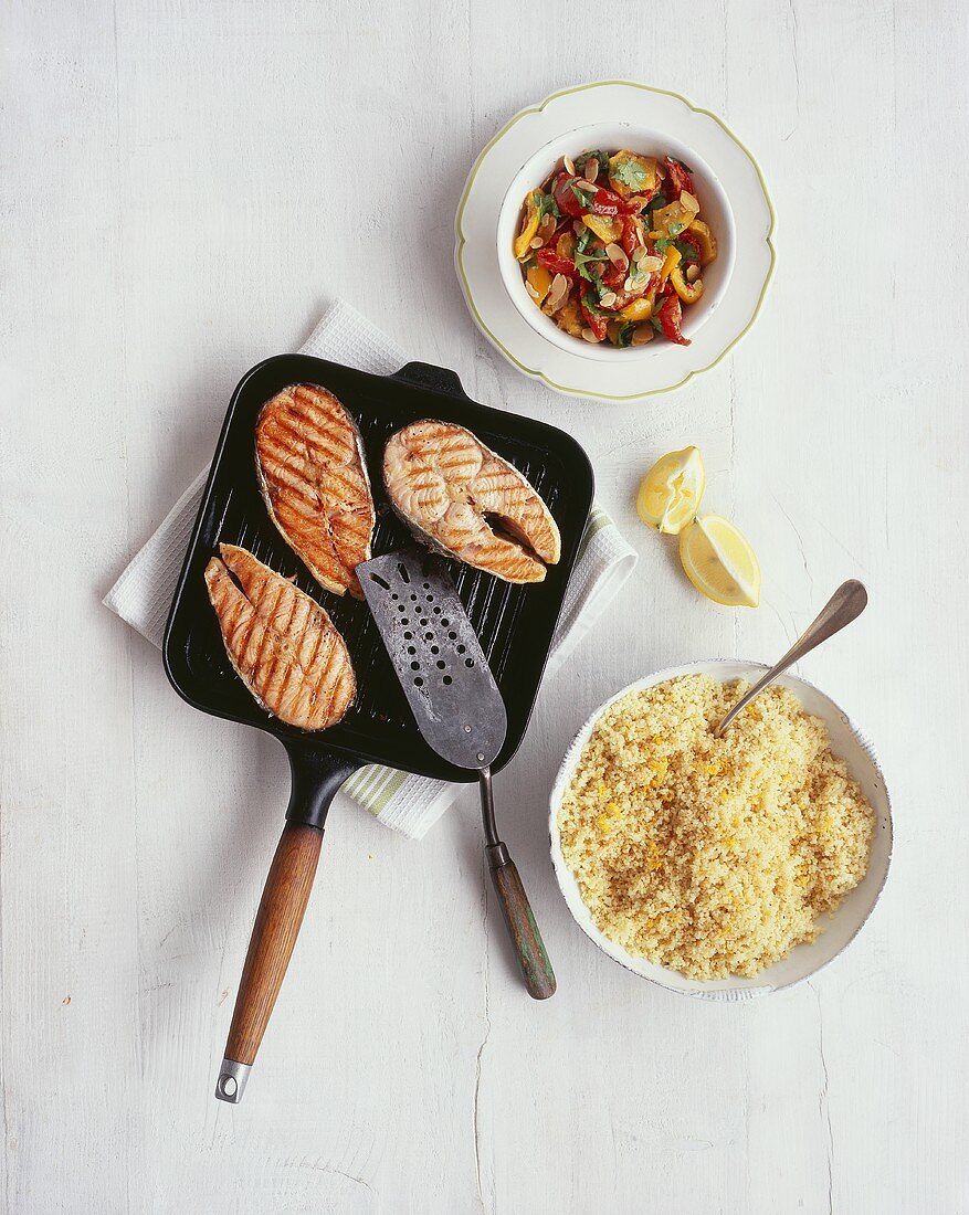 Salmon in grill pan with peppers and lemon couscous