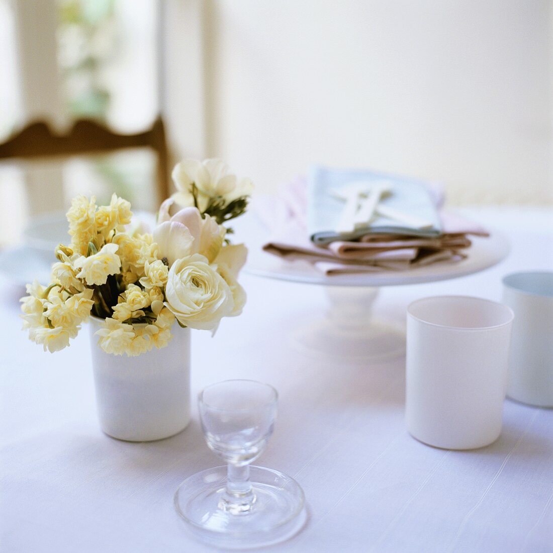 Tisch mit Geschirr, Servietten und Frühlingsstrauss