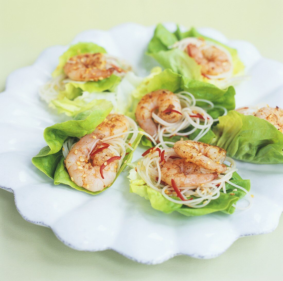 Fried chilli prawns with noodles on lettuce leaves