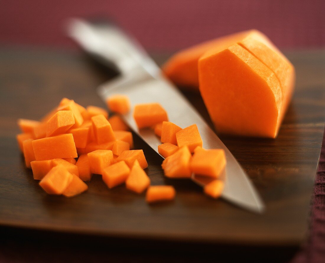 Chopped pumpkin with knife on chopping board
