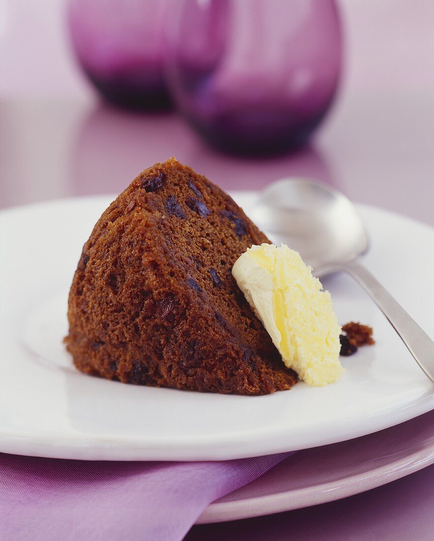 A piece of spice cake with raisins and clotted cream