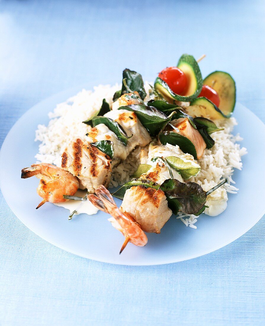 Grilled fish and vegetable kebabs on a bed of rice