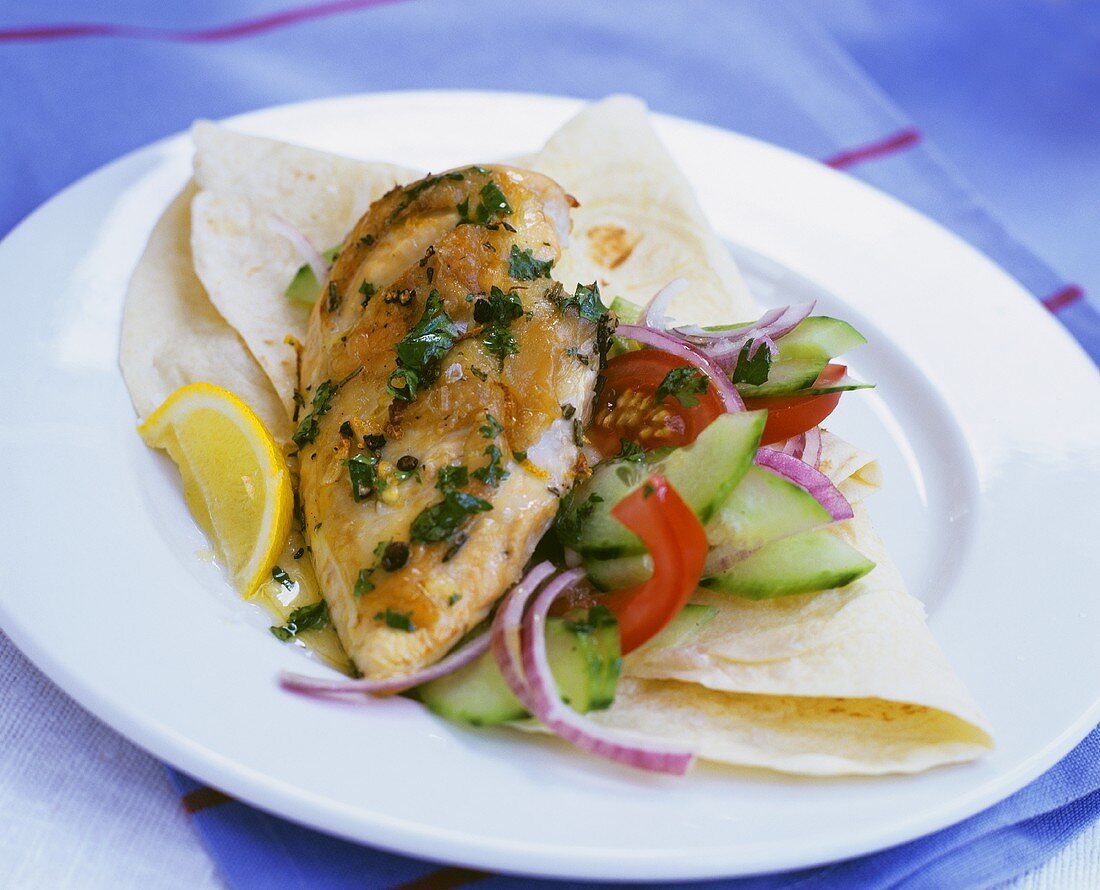 Chicken breast with cucumber-tomato salad on a tortilla