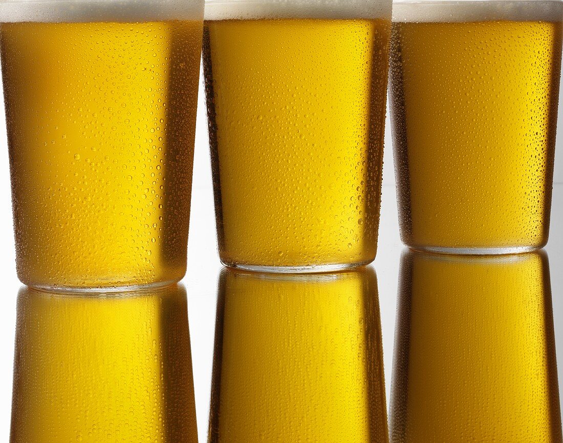 Three glasses of cold lager in a row