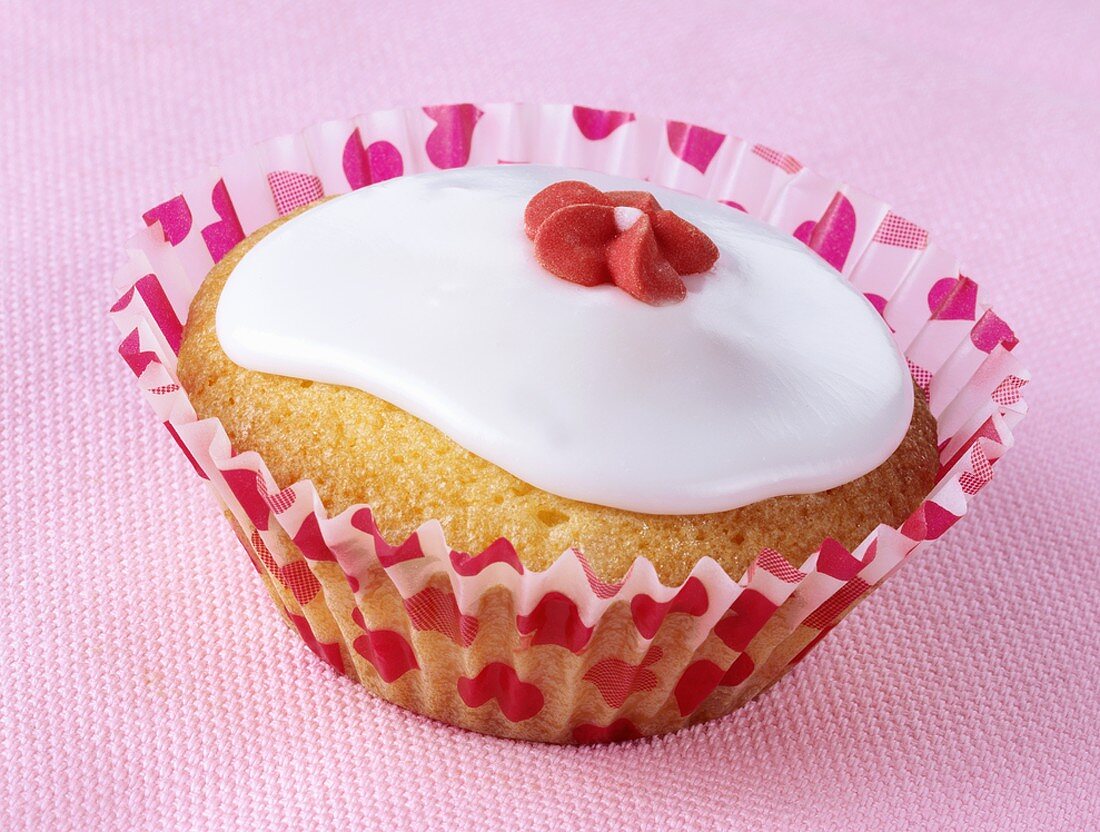 Cupcake with white icing and red sugar flower