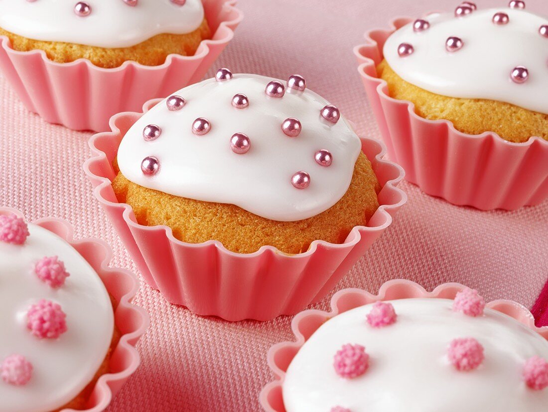 Cupcakes mit weisser Glasur und rosa Zuckerperlen