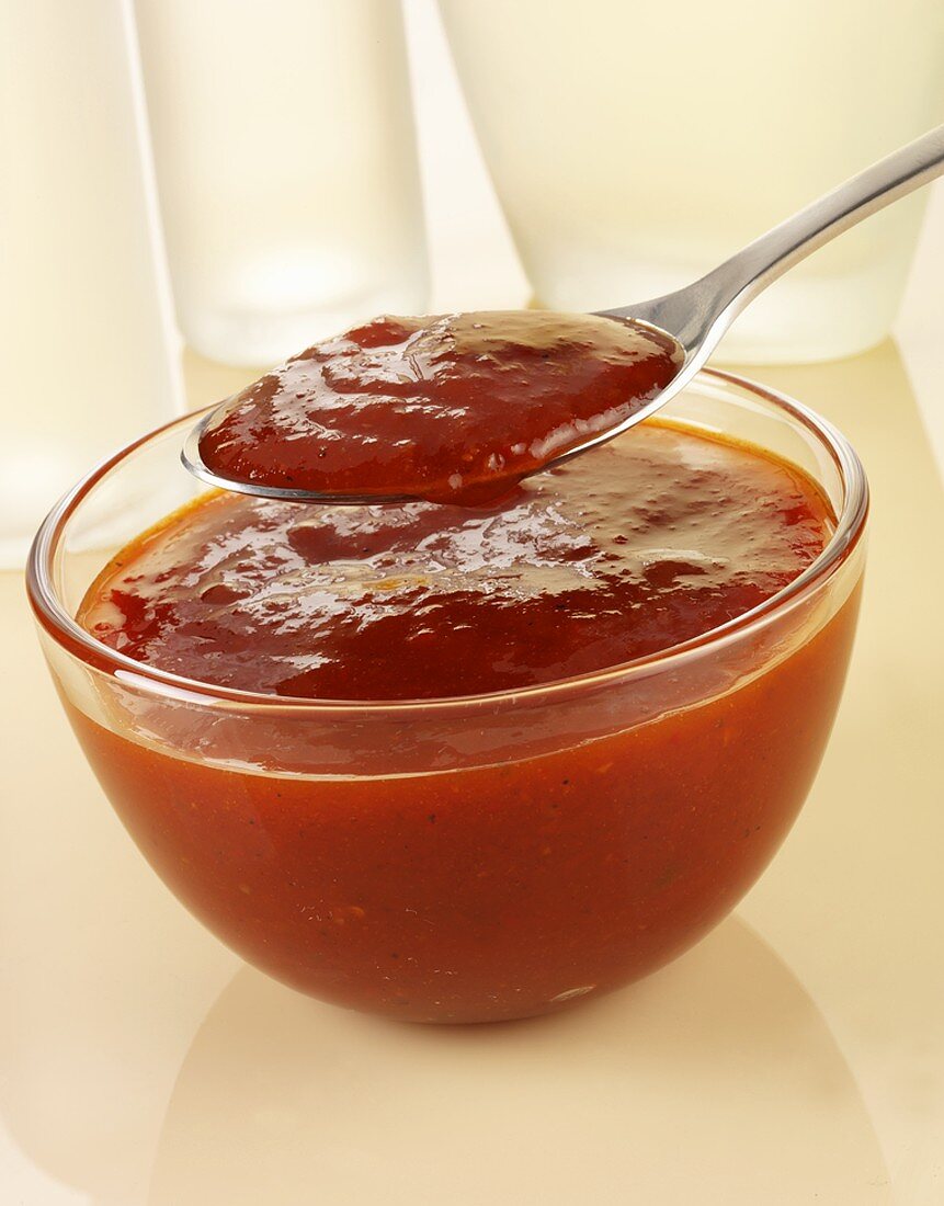Barbecue sauce in glass bowl and on spoon