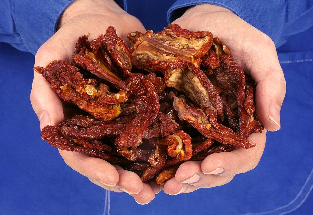 Hands holding dried tomatoes