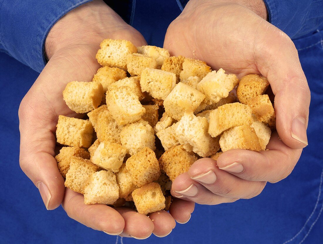 Hands holding croutons