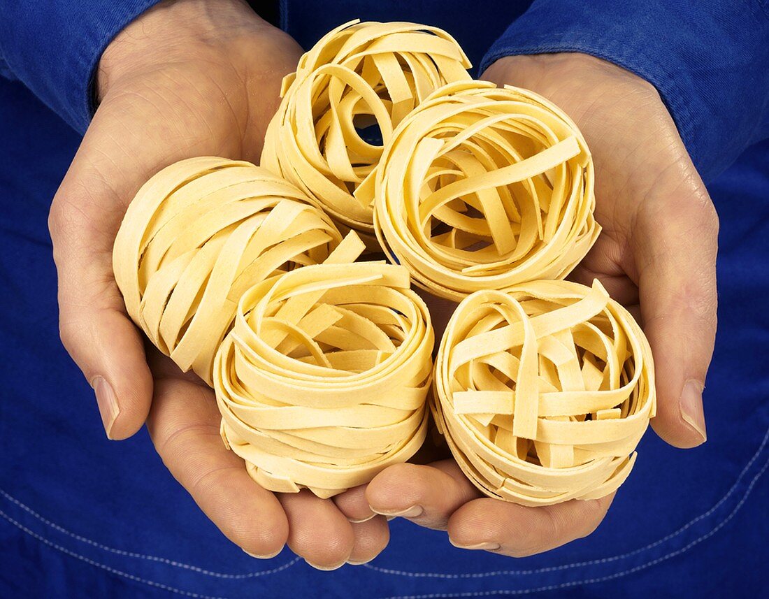 Hands holding tagliatelle