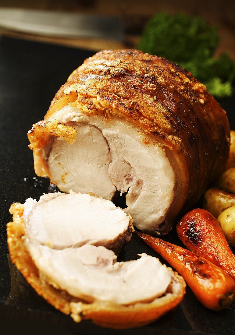Rolled pork roast with crackling, a slice carved
