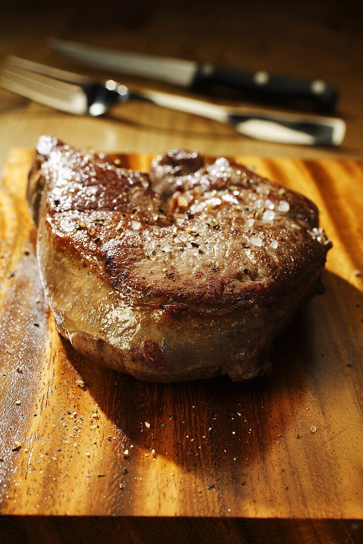 Fried venison steak on chopping board