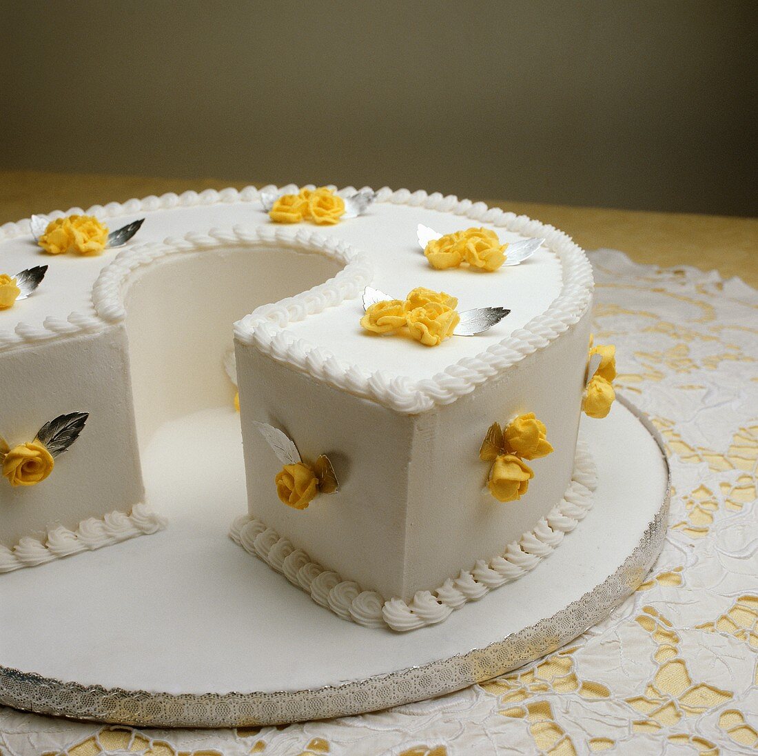 A white cake with yellow sugar roses