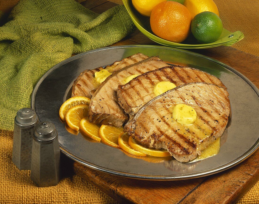 Grilled tuna steaks on orange slices