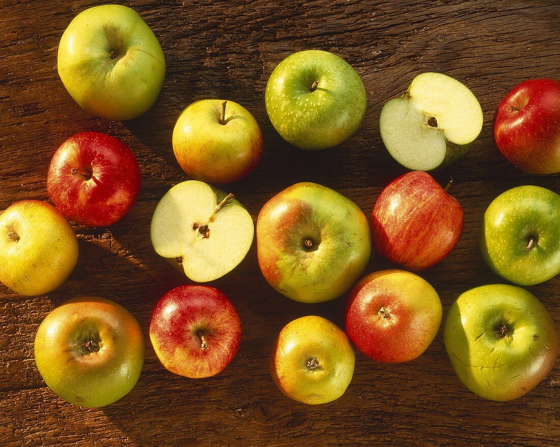Various types of apples on a wooden surface