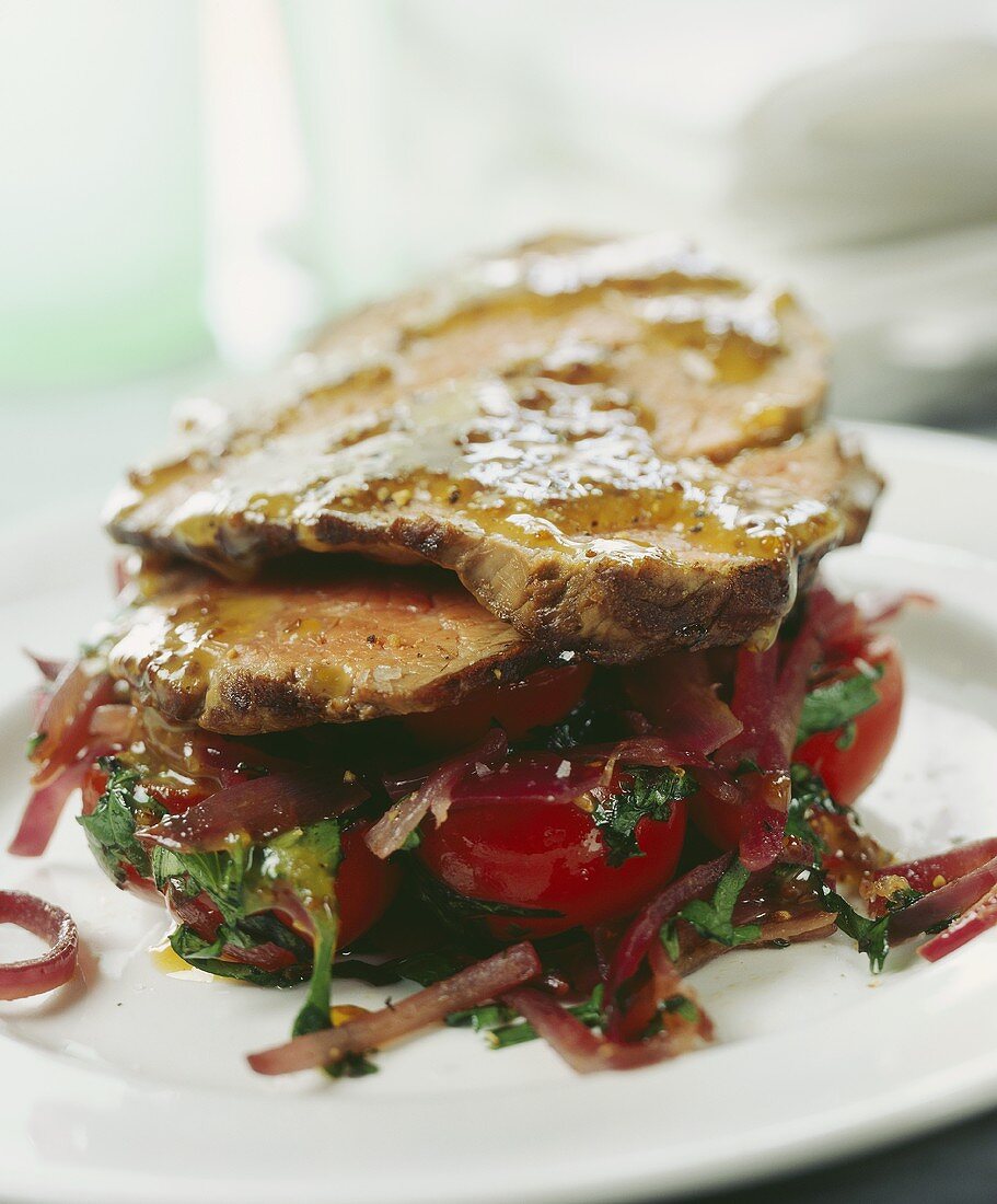 Gebratenes Rindfleisch mit Tomaten und Spinat