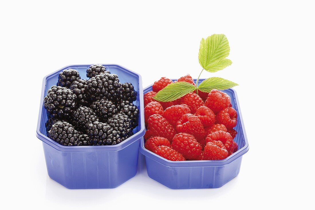Blackberries and raspberries in plastic containers