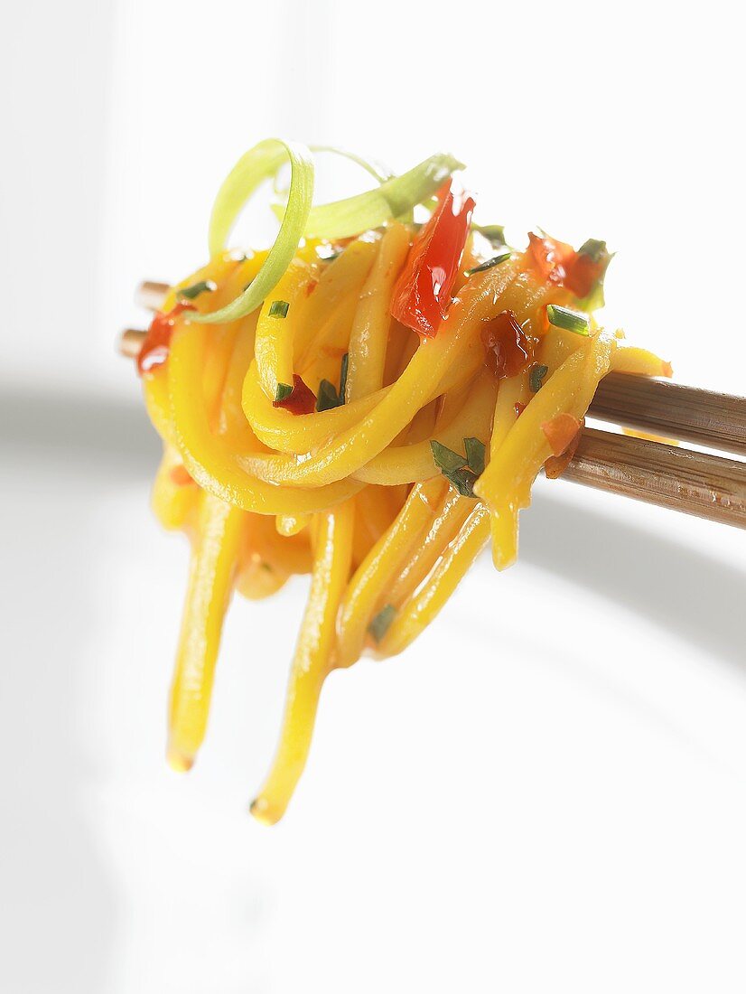 Egg noodles with vegetables on chopsticks (Asia)