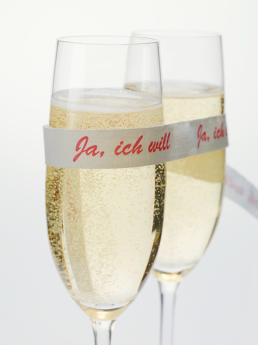 Two glasses of sparkling wine with ribbon ('I do' in German)