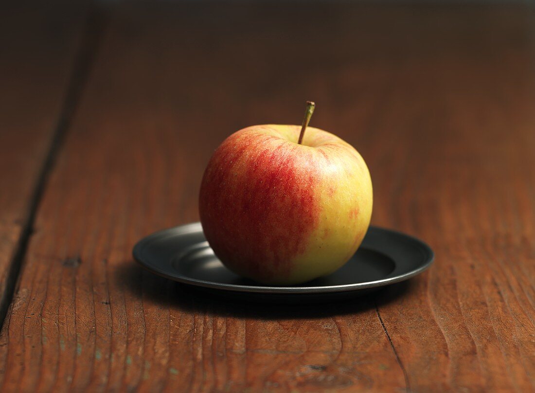 Ein Elstar-Apfel auf einem Zinnteller