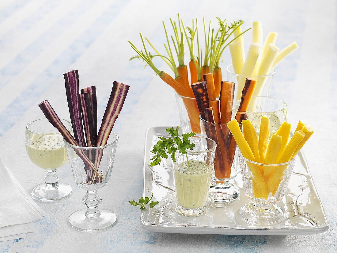 Different coloured carrot sticks and carrots with dip