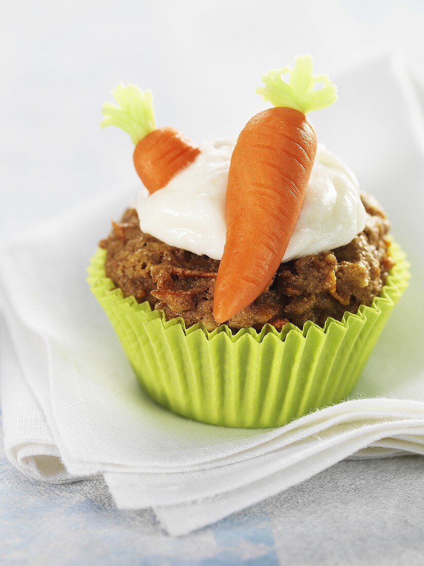 Carrot muffin with marzipan carrots and cream topping