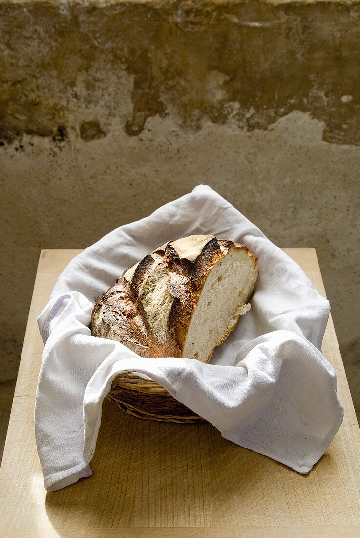 Half a loaf of white bread in a bread basket