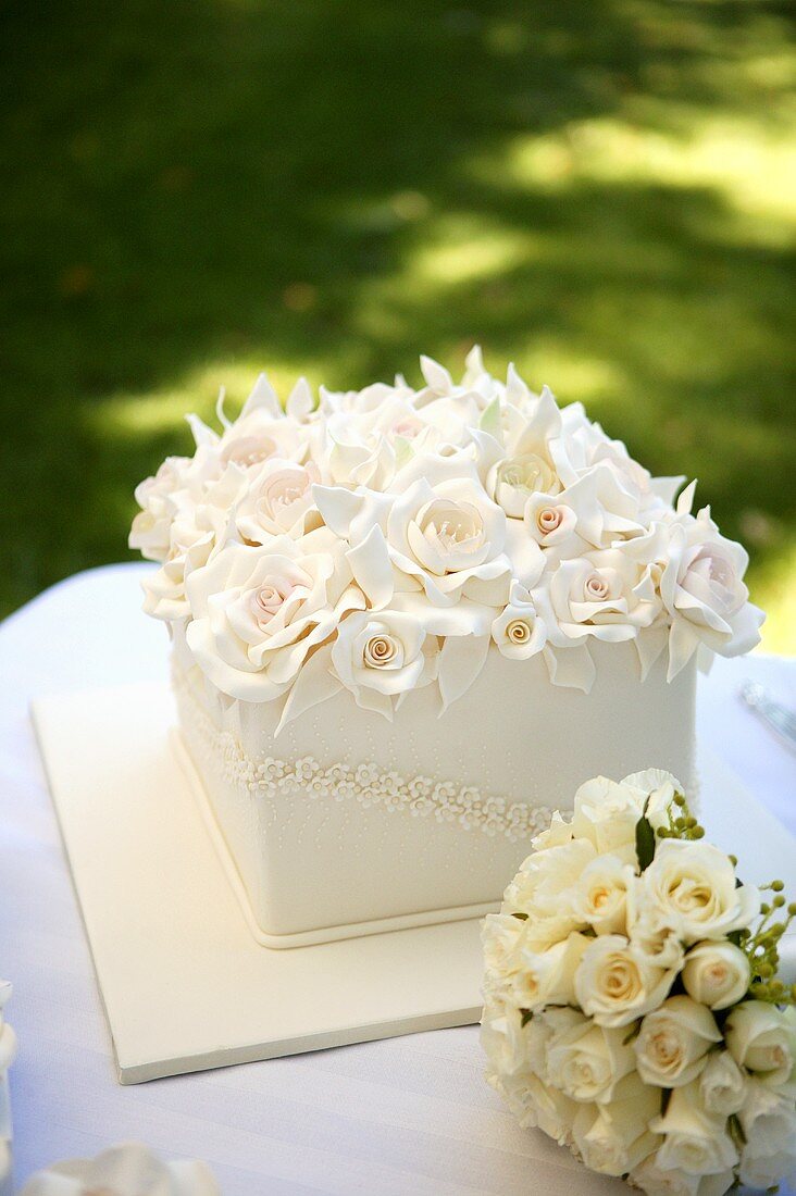 Square wedding cake with a mass of roses