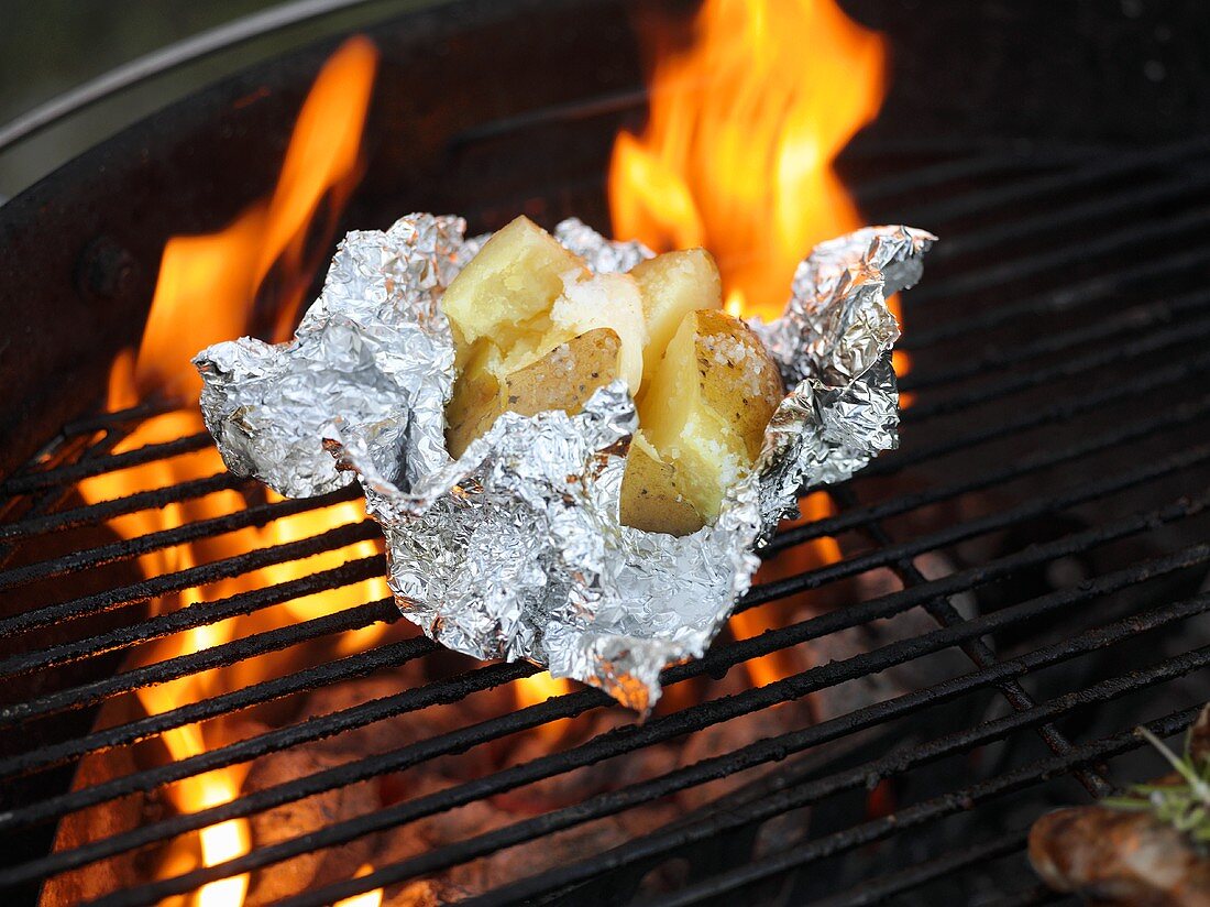Baked potato with butter on a barbecue