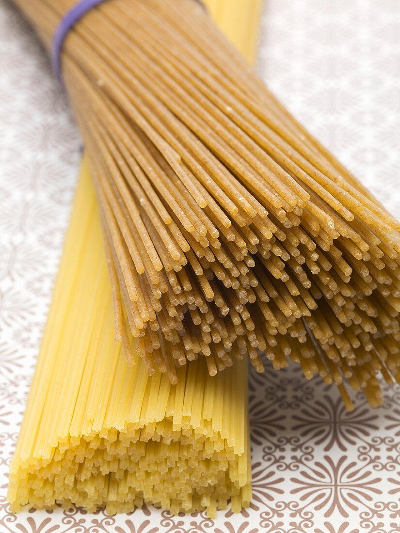 Bundle of wholemeal spaghetti on bundle of durum wheat spaghetti