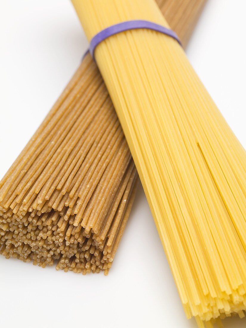 Bundle of durum wheat spaghetti on bundle of wholemeal spaghetti