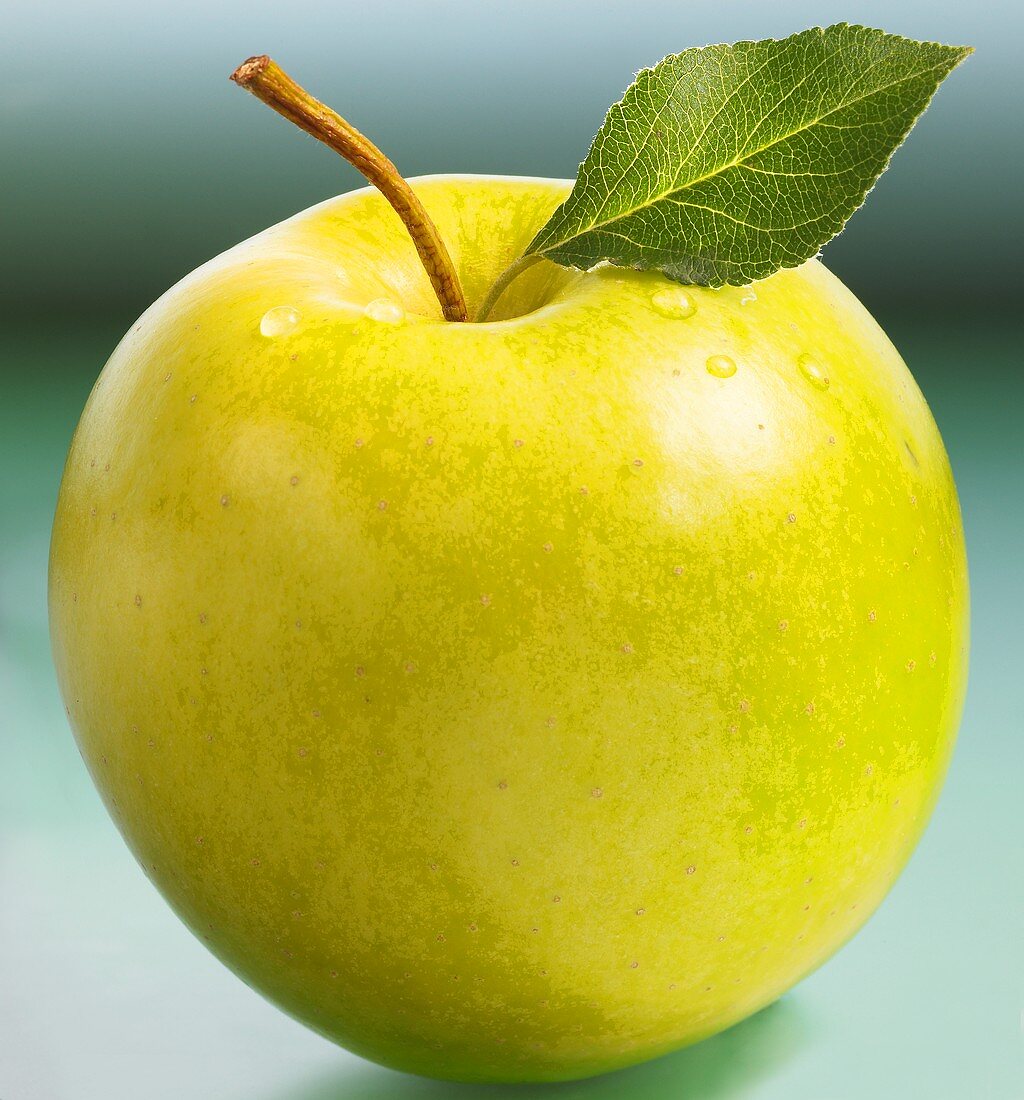 Golden Delicious apple with stalk and leaf