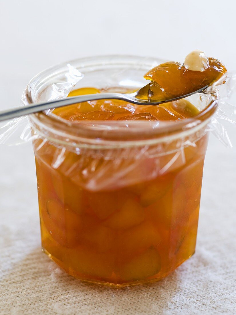 Aprikosenmarmelade mit Mandeln im Glas und auf Löffel