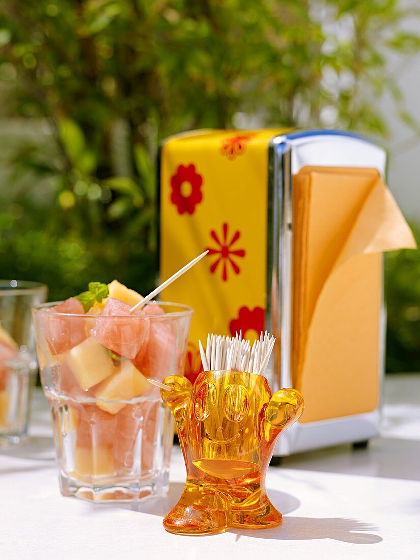 Fresh melon cubes, toothpicks, napkin holder