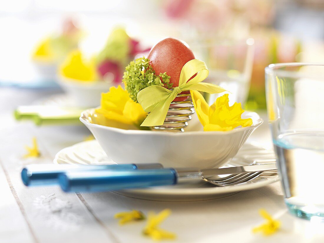 Ostergedeck mit gefärbtem Ei und Blumen