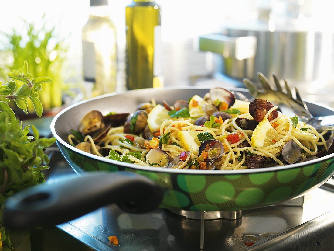 Spaghetti vongole in frying pan on cooker