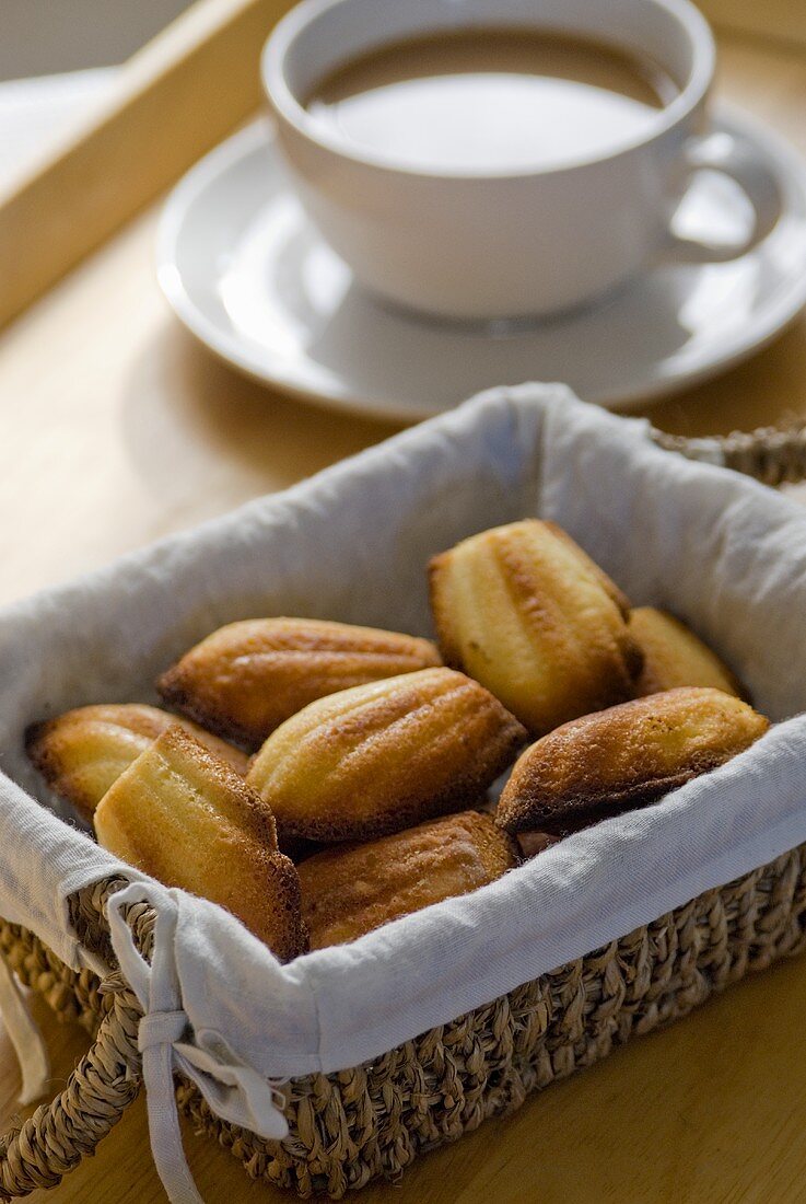 Madeleines in bread basket in front of cup of coffee