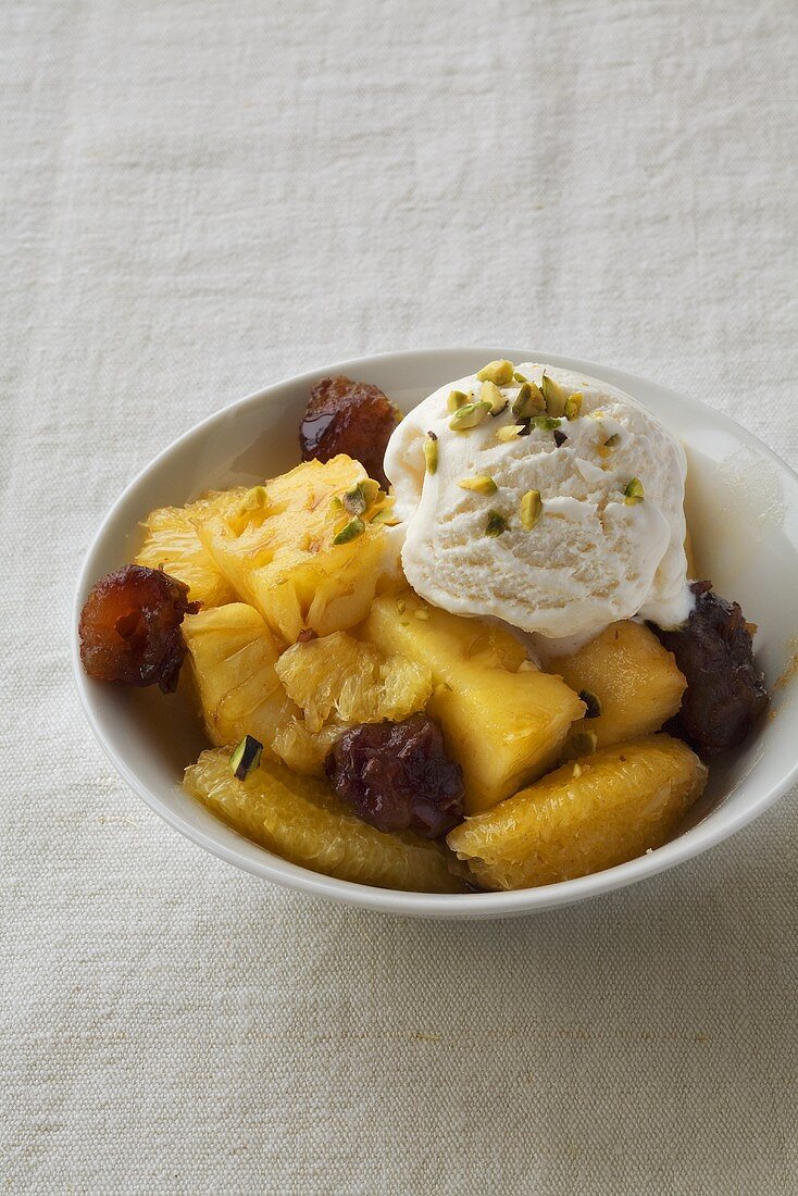 Stewed pineapple with orange and scoop of ice cream
