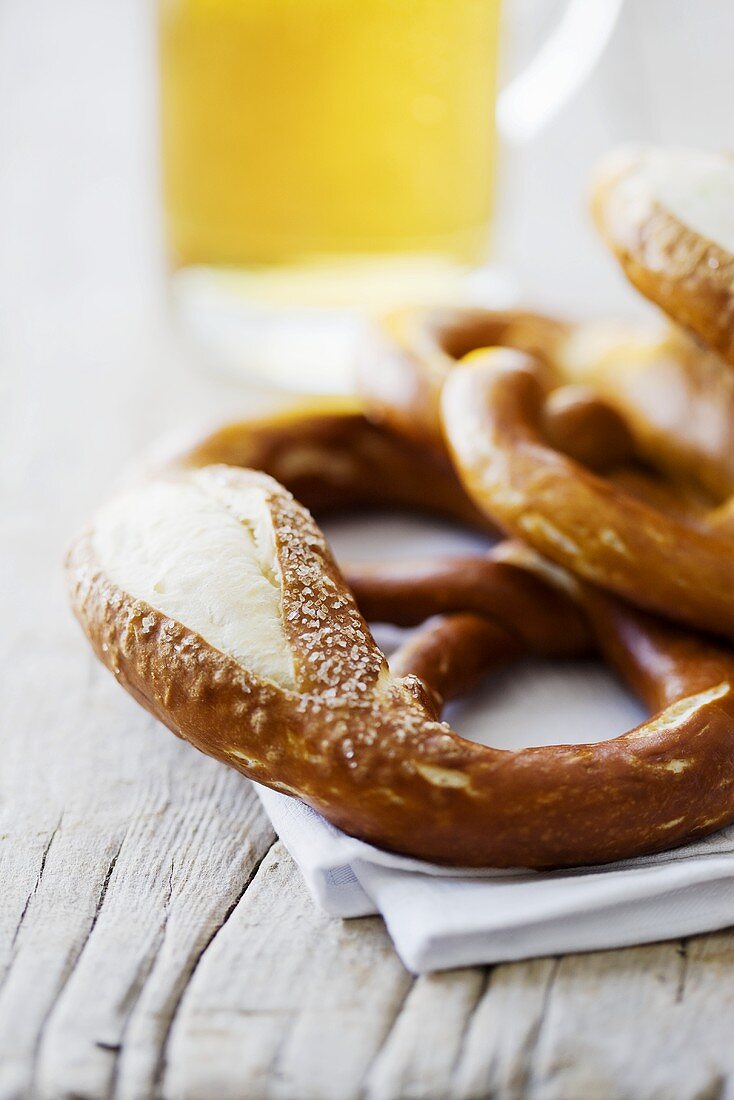 Mehrere Laugenbrezeln und Glas Bier