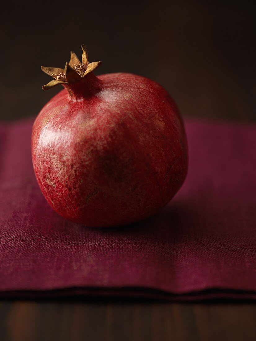 Granatapfel auf burgunderfarbenem Leinentuch