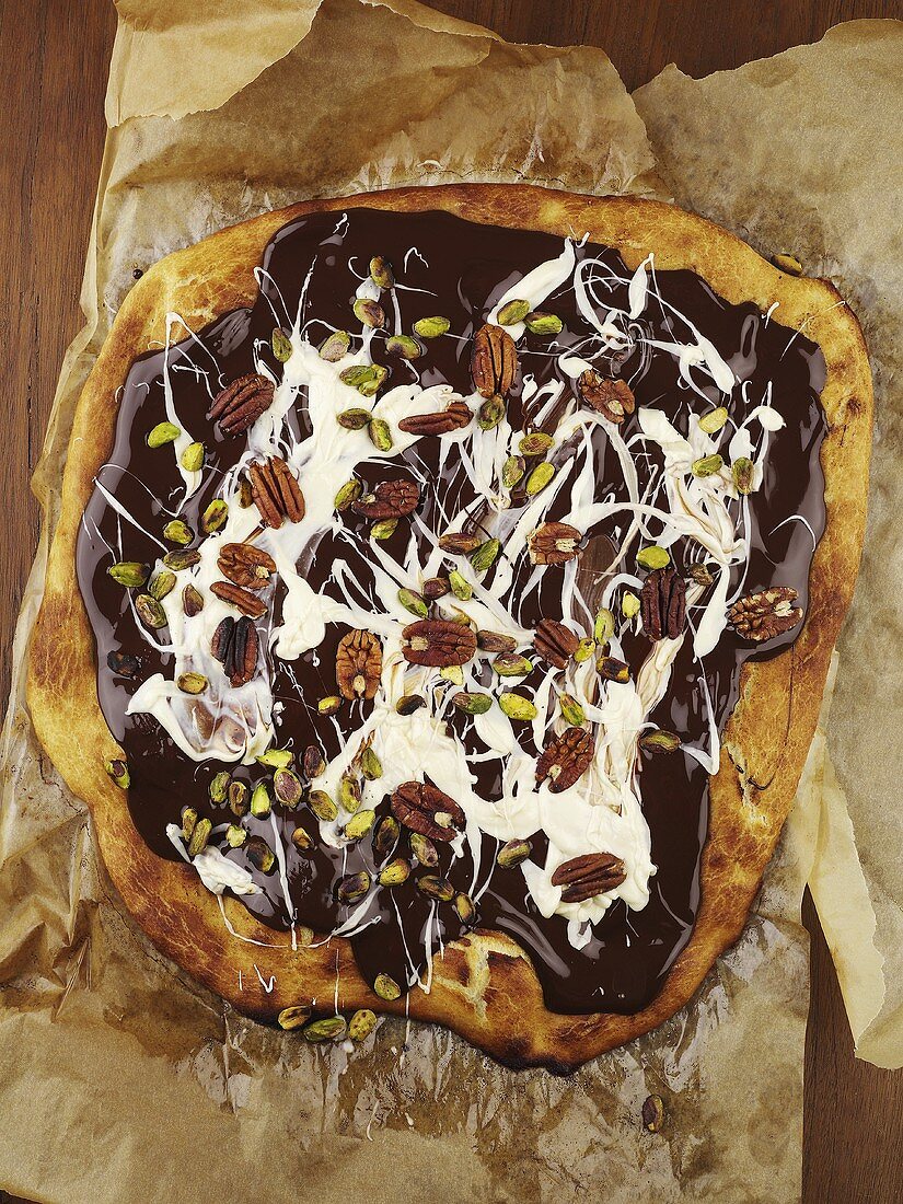 Pizza topped with chocolate sauce, cream and nuts